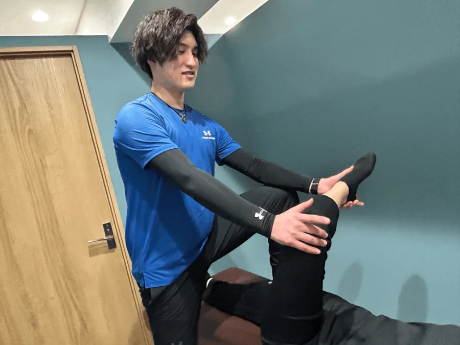 トレーナーが肩まわりを丁寧にストレッチしている様子